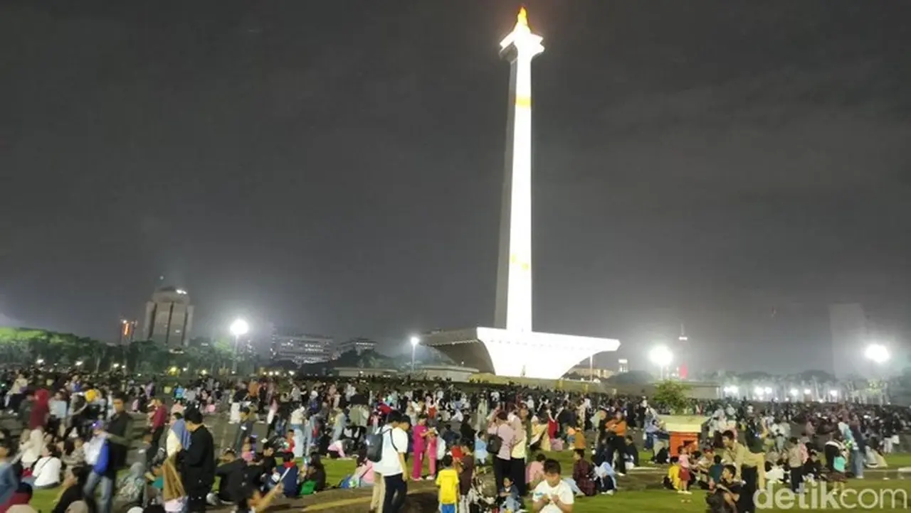 Jakarta Diguyur Hujan Malam Ini. Warga Tetap Ramai Menanti Malam Pergantian Tahun Di Kawasan Monumen Nasional (monas). (kurniawan/detikcom)