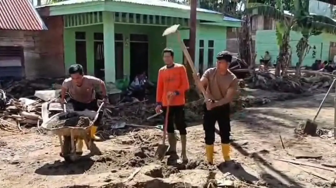 Polisi Dan Warga Membereskan Sisa Banjir Bandang Di Desa Cane Toa. (foto: Dok. Istimewa)