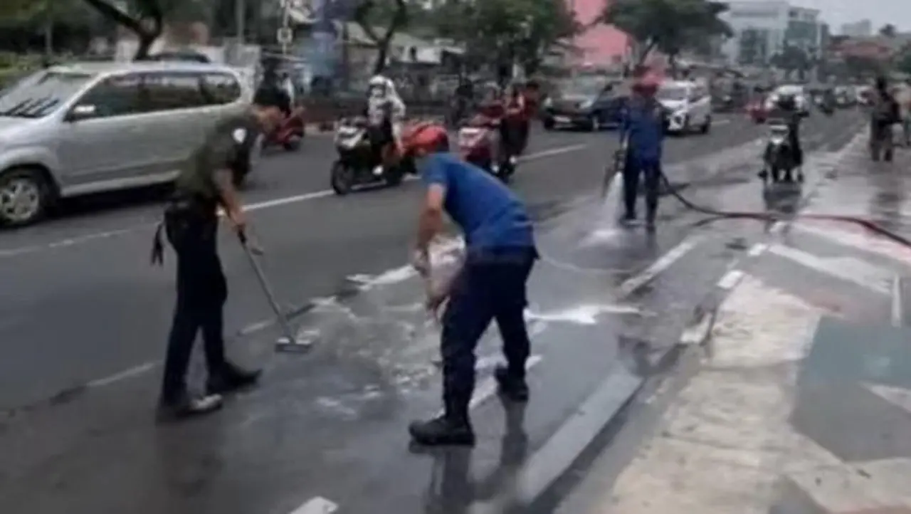 Damkar Membersihkan Tumpahan Minyak Yang Bikin Pengendara Motor Berjatuhan Di Jalan Margonda, Depok. (dok. Damkar Depok)