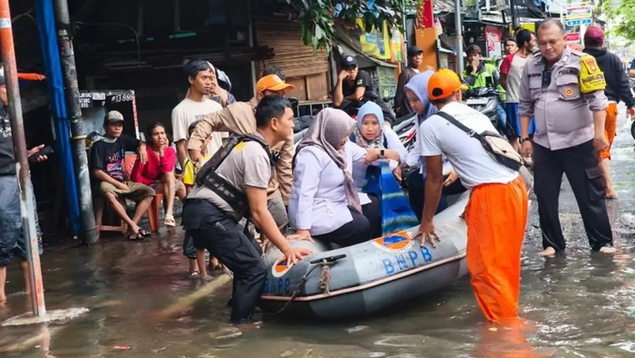 Foto: Polisi Bersama Ppsu Dan Bpbd Mengevakuasi Guru Terluka Usai Kecelakaan Ketika Terjadi Banjir Di Pademangan, Jakut (dok Polres Jakut)