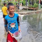 Banjir Pegangsaan Dua: Anak-anak Asyik Tangkap Ikan untuk Lauk Goreng