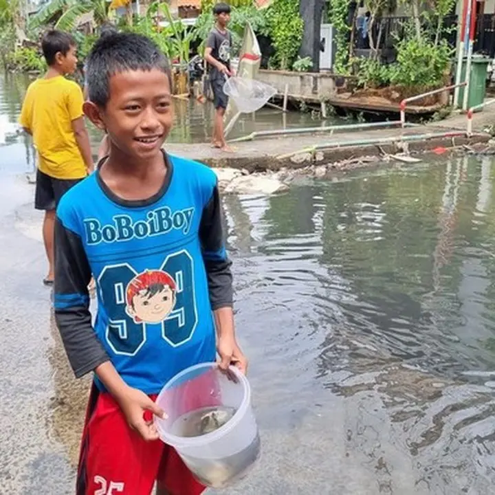 Banjir Pegangsaan Dua: Anak-anak Asyik Tangkap Ikan untuk Lauk Goreng