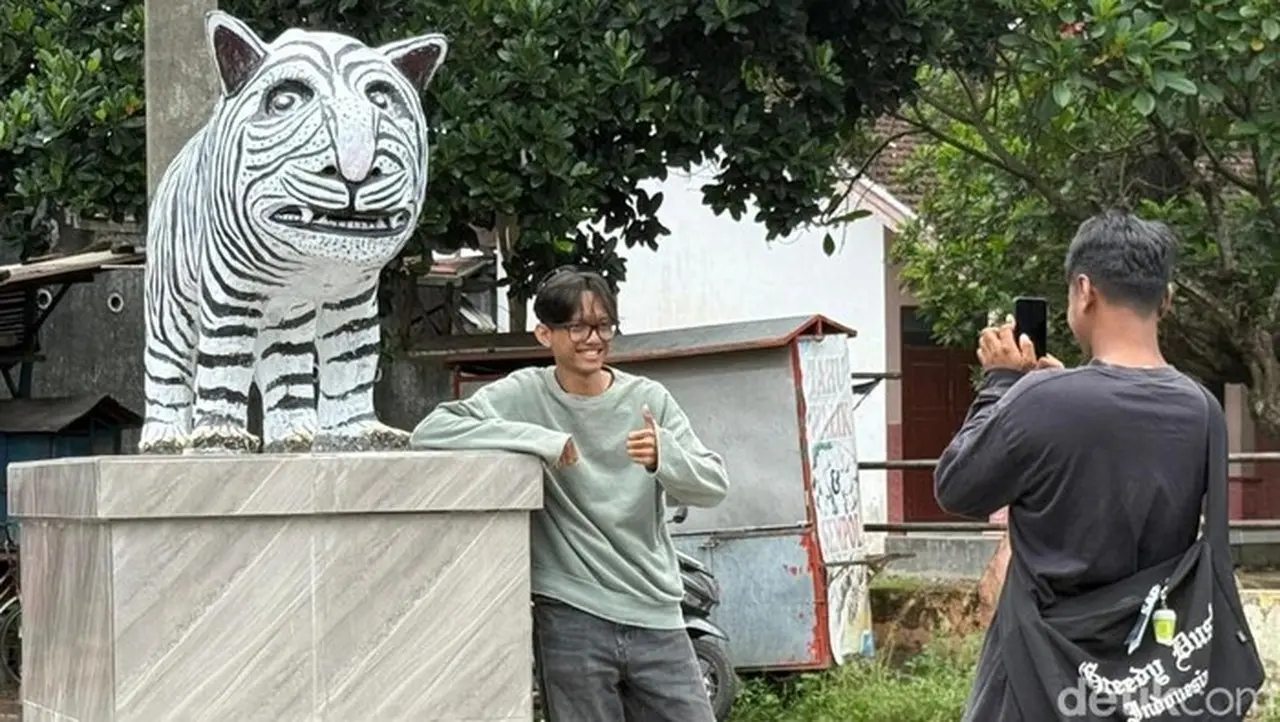 Sejumlah Warga Berfoto Dengan Patung Macan Putih Di Kediri Yang Viral Karena Bentuknya Lucu. (andhika Dwi/detikjatim)