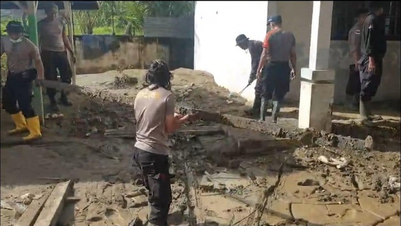 Polisi Turun Tangan Bersihkan Lumpur Banjir di SMAN 1 Peusangan Bireuen