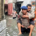 Brimob Polda Metro Gendong Warga Sakit Terjebak Banjir di Kedaung Kali Angke, Jakarta Barat