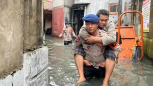 Brimob Polda Metro Gendong Warga Sakit Terjebak Banjir di Kedaung Kali Angke, Jakarta Barat