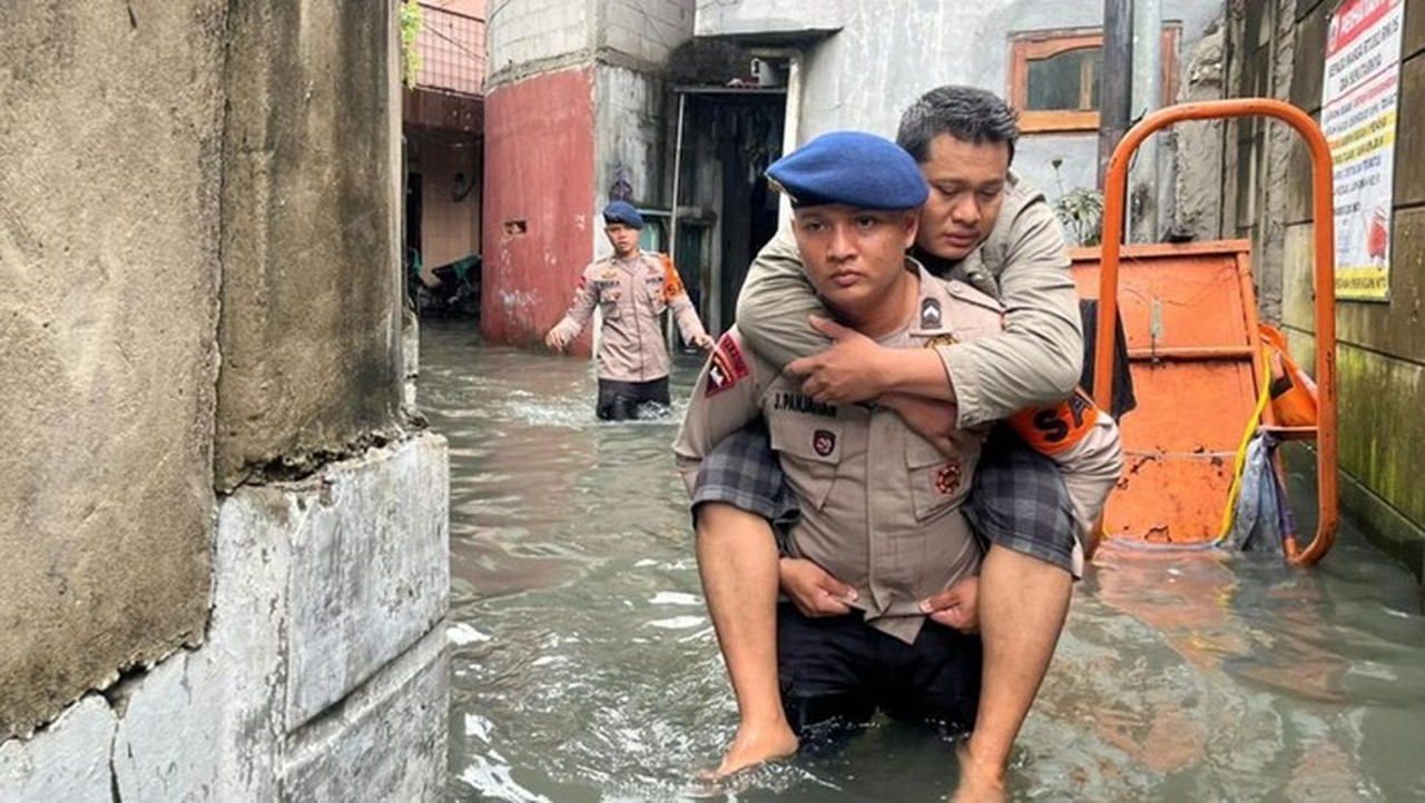 Brimob Polda Metro Gendong Warga Sakit Terjebak Banjir di Kedaung Kali Angke, Jakarta Barat